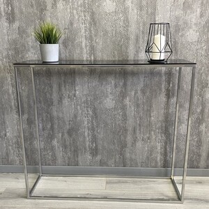 

Напольная консоль Akur Loft Norman 1200 металлокаркас хромированный тонированное стекло, Loft Norman 1200 металлокаркас хромированный тонированное стекло
